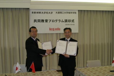 共同教育プログラムに関する協定書を交わし握手するKCGIの寺下陽一教授（左）と，大連理工大学城市学院の匡国柱院長
