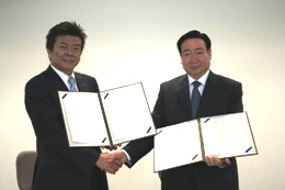 学術交流協定書を交わし握手する林世選・鄭州軽工業学院校務委員会主席(右)と長谷川亘・KCG統括理事