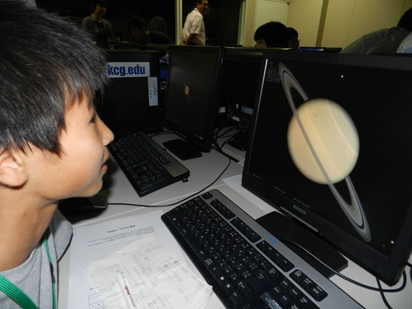 専用ソフトを使ってパソコン上で天体観測。参加した小学生は，画面に土星が現れ興奮気味。