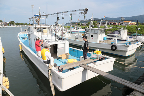 青雲丸に乗船，必要なものを積み込みます。携帯電話を防水ケースへ入れ，ライフジャケットを着ます。