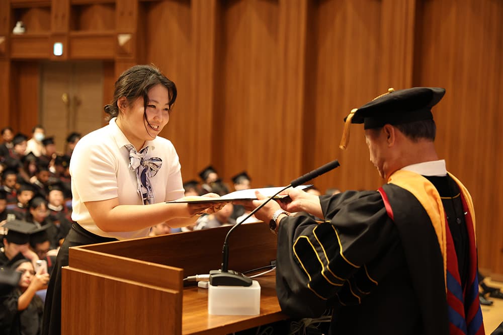 KCG卒業生代表に卒業証書と称号授与書を授与する高弘昇洛北校校長（同，同）
