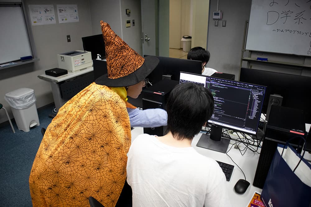 仮装姿の学生スタッフと一緒に,楽しみながらプログラミングを体験
