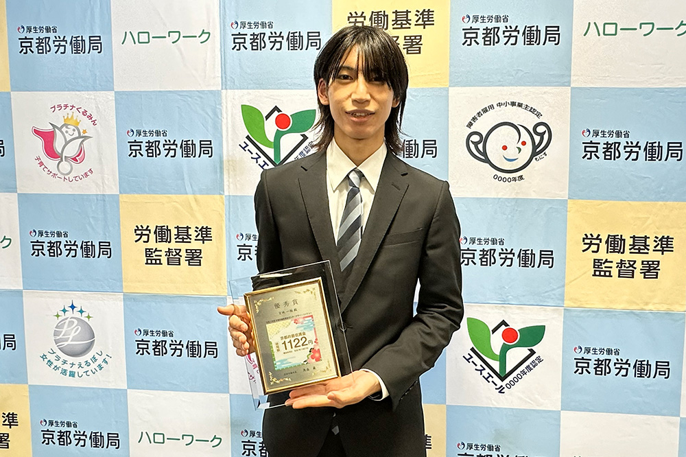令和7年度（2025年度）京都府最低賃金ポスターデザインコンテストで優秀賞に輝き，賞状を受けたアート・デザイン学科の宮地さん（京都労働局）