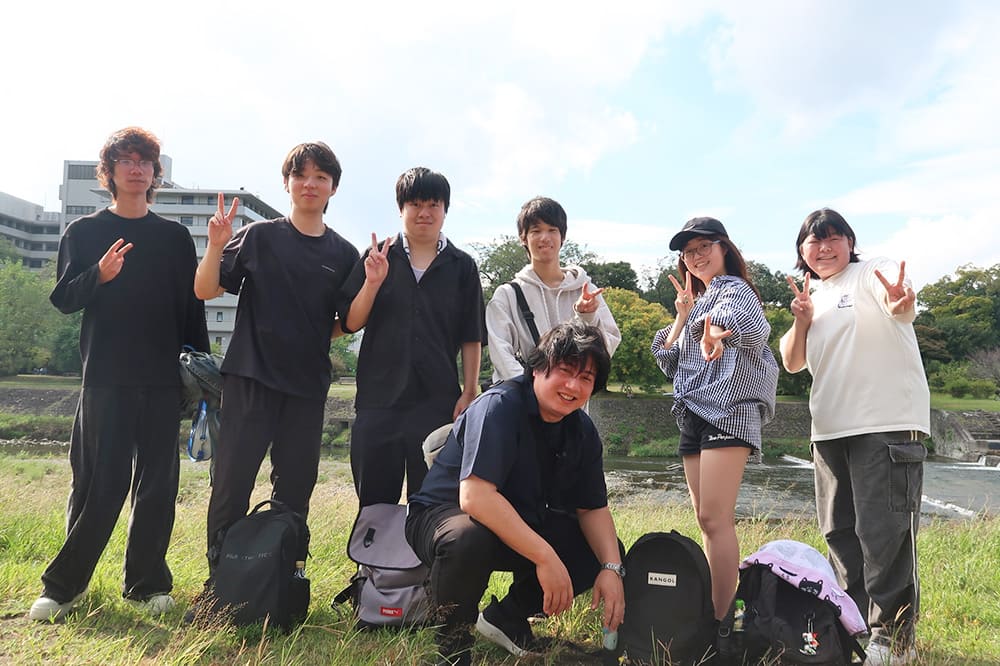 青空の下，鴨川沿いの景色を楽しみながら，引率の先生と一緒に笑顔でパシャリ！